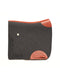 A side-view image of a dark charcoal felt horse saddle pad with bright orange leather trim and wear leathers, featuring a laser-cut herringbone border on the back half, isolated on a white background.