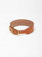A wide cognac brown leather dog collar from Manifattura VALOR featuring a solid brass roller buckle, an integrated D-ring, and a subtly embossed V shield monogram logo.