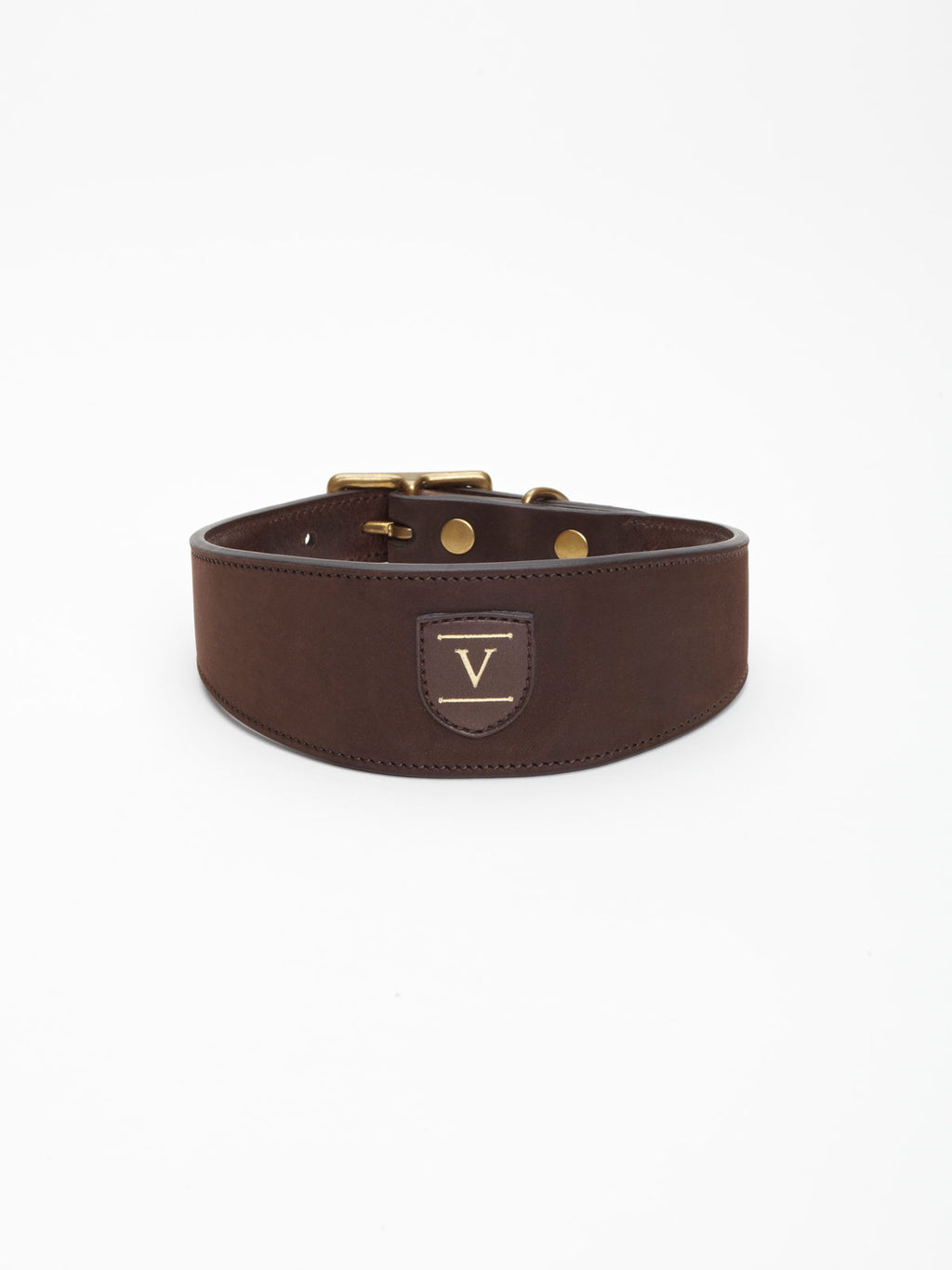 A wide dark brown nubuck leather dog collar from Manifattura VALOR featuring a gold-embossed V shield logo patch and polished brass hardware rivets.