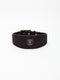 A wide black nubuck leather dog collar from Manifattura VALOR featuring a gold-embossed V shield logo patch and polished brass hardware rivets.