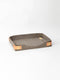 Manifattura Valor rollable dog bed in grey wool felt, open flat with tan leather straps and buckle.