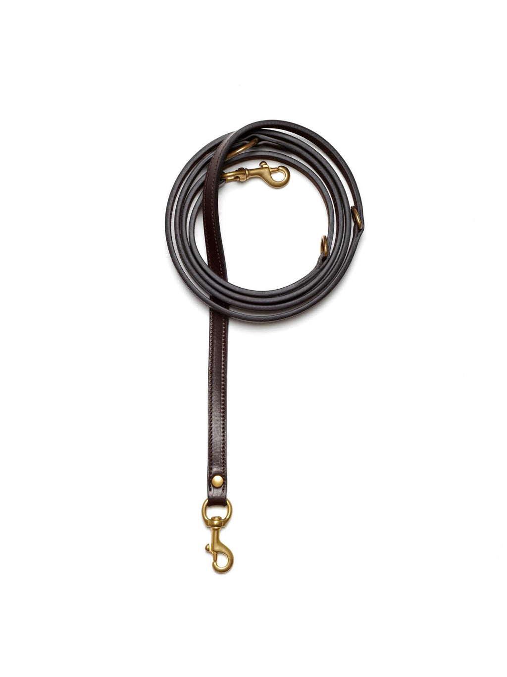 A dark espresso brown stitched leather dog lead from Manifattura VALOR coiled neatly, featuring solid brass swivel snap hooks on both ends and multiple integrated hardware adjustment rings.