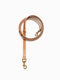 A cognac brown stitched leather dog lead from Manifattura VALOR coiled neatly, featuring solid brass swivel snap hooks on both ends and multiple integrated hardware adjustment rings